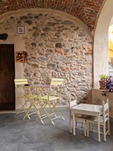 two chairs and a table in front of a stone wall at Cà d'Margherita and Heidi in Valdieri
