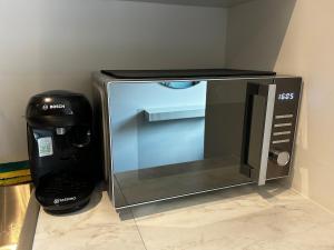 a microwave sitting on a counter next to a coffee maker at Le Petit Gaillard in Les Andelys +3 photos