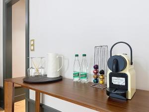 a wooden table with a blender and bottles on it at La suite du Brésil - Centre historique du Puy in Le Puy-en-Velay