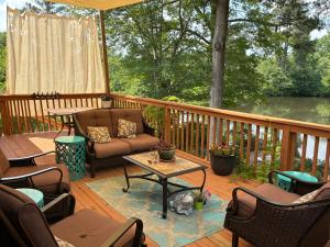 a porch with a couch and a table on a deck at Lakefront Serenity in Marietta