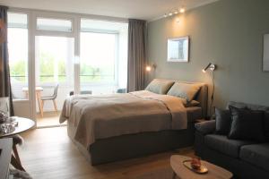 a bedroom with a bed and a living room with a couch at Apartment Nordly in Wendtorf