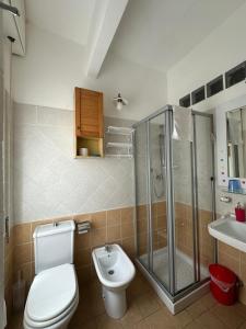 a bathroom with a toilet and a shower and a sink at Dreaming Rooms in Riomaggiore