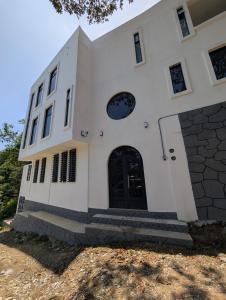 a white building with a black door and stairs at Hotel de la Montaña in Huautla de Jiménez +24 photos