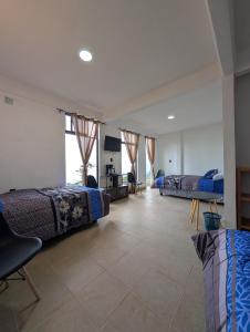 a bedroom with two beds and a desk and a tv at Hotel de la Montaña in Huautla de Jiménez