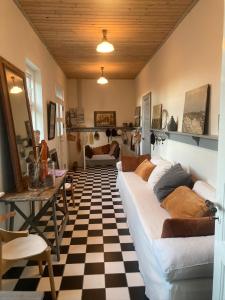a living room with a couch and a checkered floor at La Petite Ecole in Bindslev +27 photos