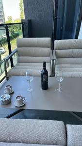 a bottle of wine and two glasses on a table at Beach Apartment Chakvi in Chakvi