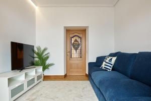 a living room with a blue couch and a door at Kai in Getaria