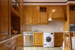 a kitchen with wooden cabinets and a washing machine at Kai in Getaria