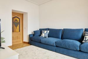 a blue couch sitting in a living room at Kai in Getaria