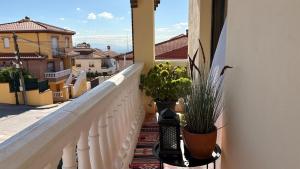 a balcony with two potted plants on a building at Casa El Jazmín in Alfacar