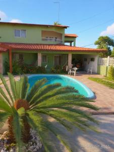 a house with a palm tree in front of it at Pitimbu Beach House Rosi in Pitimbu