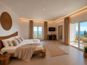 a bedroom with a large bed and a large window at Domi Drymades in Dhërmi