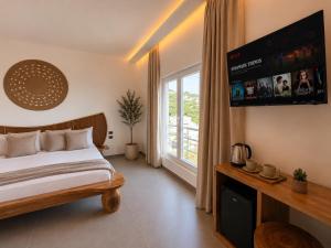 a bedroom with a bed and a large window at Domi Drymades in Dhërmi