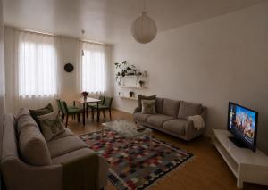 a living room with a couch and a tv and a table at Central Hub in Brussels
