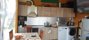 a kitchen with wooden cabinets and a table and a refrigerator at Вила Никови in Durankulak