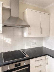 a kitchen with white cabinets and a stove top oven at 11 Netherby Street in Longtown