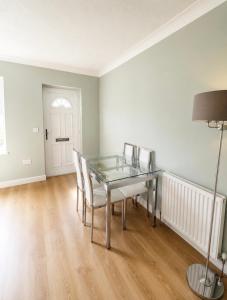 a dining room with a glass table and chairs at 11 Netherby Street in Longtown