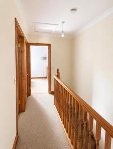 a hallway with a wooden staircase and a door at 11 Netherby Street in Longtown