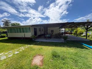 a house with a patio and a grass yard at Chez Taia in Tiputa