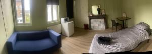a living room with a blue couch and a bed at les chambres Carnot in Elbeuf