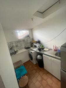 a small kitchen with a sink and a washing machine at les chambres Carnot in Elbeuf