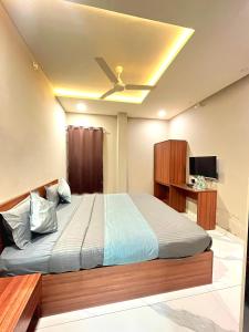 a bedroom with a bed with a ceiling fan at Hotel Golden Glory Scheme 103 in Indore