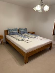 a bedroom with a wooden bed with blue pillows at Apartment Laura in Wilderswil