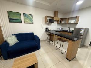 a living room with a blue couch and a kitchen at “SC Apartments” Equipetrol in Santa Cruz de la Sierra