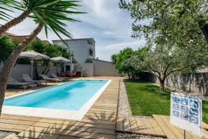 a swimming pool in the backyard of a house at Apartmani Pocco Locco in Biograd na Moru +29 photos