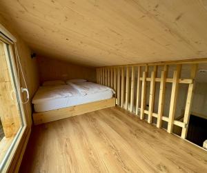 a small room with a bed in a wooden cabin at Mokuzo Tiny Houses in Lauingen