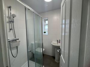 a bathroom with a shower and a toilet and a sink at London Heathrow Hayes Escape in South Ruislip Station