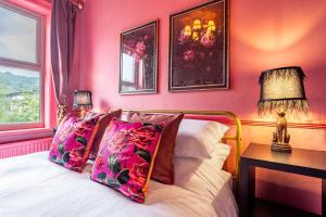a bedroom with pink walls and a bed with pink pillows at Lindores Bed & Breakfast in Todmorden