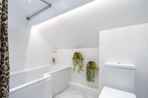 a white bathroom with a tub and a toilet at Lindores Bed & Breakfast in Todmorden
