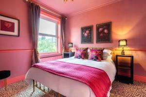 a pink bedroom with a bed and a window at Lindores Bed & Breakfast in Todmorden