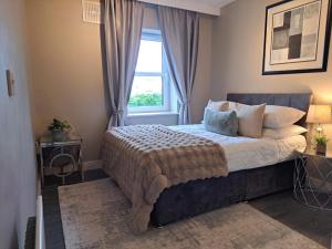 a bedroom with a large bed with a window at 2 Bedr Portmarnock Dublin Suburb in Dublin