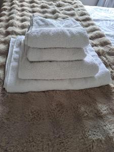 a pile of white towels sitting on a bed at 2 Bedr Portmarnock Dublin Suburb in Dublin
