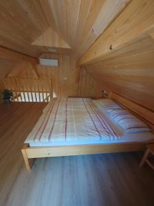 a bed in a wooden room in a attic at Honey house in Zgornje Gorje