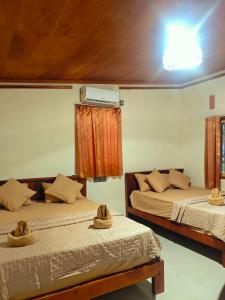 two beds in a room with hats on them at Naicha Green in Tetebatu