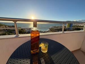 a bottle of alcohol sitting on a table on a balcony at Apartments Vila Ardi in Sarandë