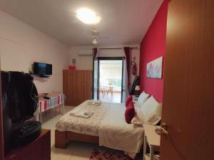 a bedroom with a bed and a red wall at Da Rosa in Letojanni