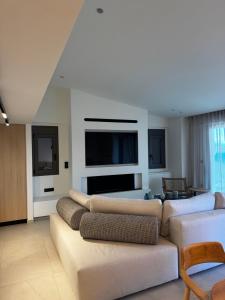 a living room with a couch and a flat screen tv at Villa Incanto in Nydri