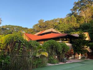 a house with an orange roof in the forest at Grand Selva Lodge & Tours in Tena