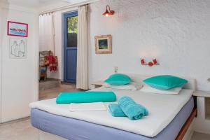 a bedroom with two beds with blue and white pillows at Rosys Little Village in Skala +121 photos