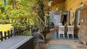a wooden porch with chairs and a table and a tree at Chambre d'hôte SOJANI in Romenay