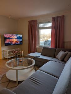 a living room with a couch and a table at Leilighet in Bjørkheim