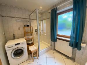 a washing machine in a bathroom with a shower at Haus Mayerbüchler - Chiemgau Karte in Inzell +34 photos