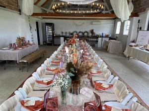 a long table in a room with white tables and chairs at Wingårdhs B&B Österlen in Löderup