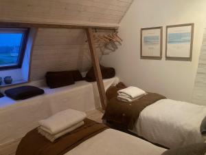 a room with three beds and a window at La Petite Ecole in Bindslev