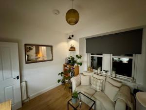 a living room with a couch and two windows at The Nook Dunblane in Dunblane
