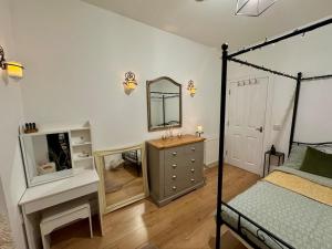 a bedroom with a bed and a dresser and a mirror at The Nook Dunblane in Dunblane